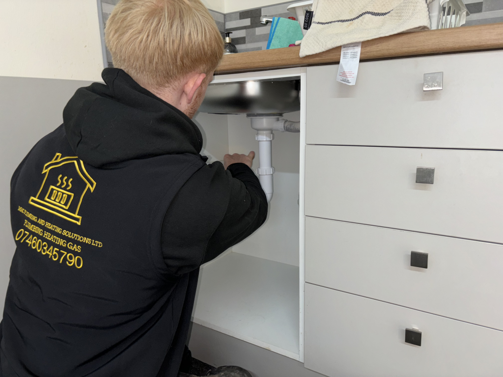 Mac Plumbing and Heating Technician peforming a repair on a sink in Horwich